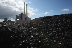 NEUMUENSTER, GERMANY - AUGUST 3:  The coal and garbage burning power plant of Statdtwerke Nuemuenster stands behind a mound of coal August 3, 2007 in Nuemuenster, Germany. The plant, which formerly relied solely on coal, is now equipped with a specialized furnace that allows the plant to produce two-thirds of its energy with garbage, which it receives from a local garbage processing center. The center, known as a Mechanisch-Biologisch Abfallbehandlungsanlage (MBA), or Mechanical-Biological Waste Processing Center, converts 55% of the garbage it receives into high-energy fuel, which it then sends to the city's converted power plant. The plant's management cites the twofold environmental benefit of burning the garbage, namely that it prevents the emission of methane gas from the biodegradation of the garbage (methane gas is 21 times more potent at warming the earth's atmosphere than CO2), and the reduced CO2 emissions from burning the garbage rather than coal.  (Photo by Sean Gallup/Getty Images)